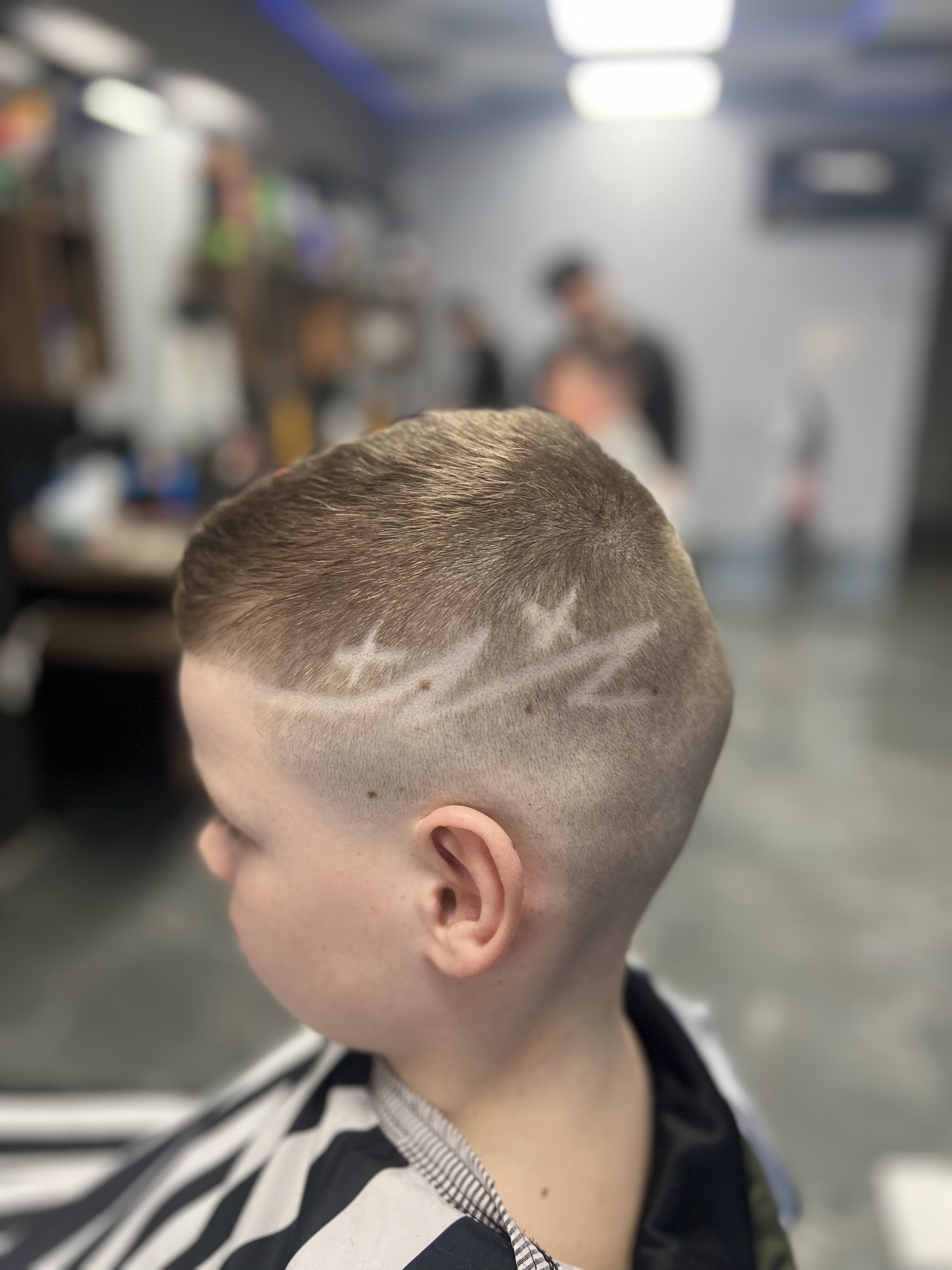 Jongen met een korte fade en een design van lijnen aan de zijkant